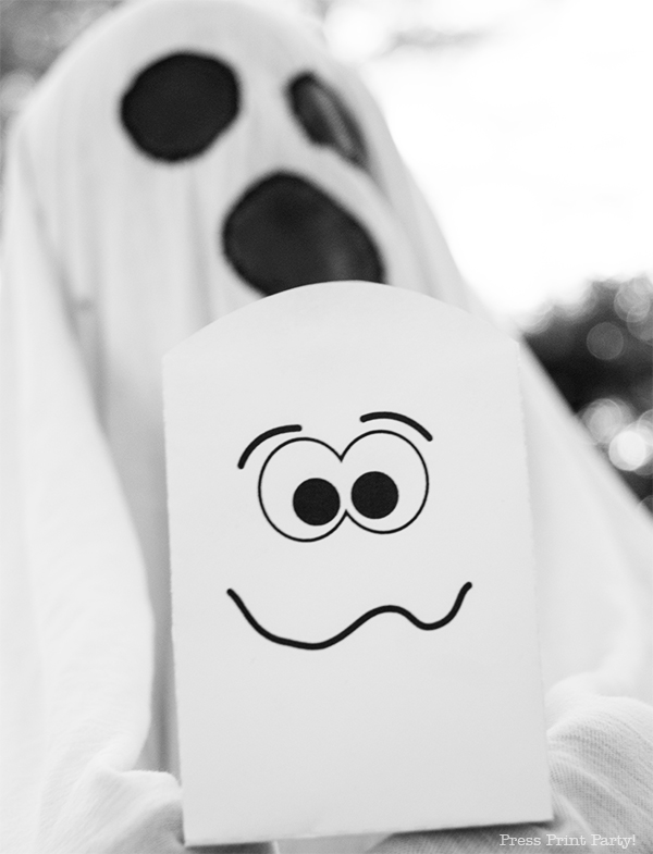 Free Halloween treat bag Printables - kid in ghost costume holding treat bag. press print party