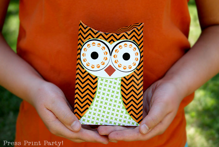 Free printable owl halloween treat boxes, favor bags, Orange, purple and green. Girl with orange shirt holding 2 owl pillow boxes by Press Print Party!