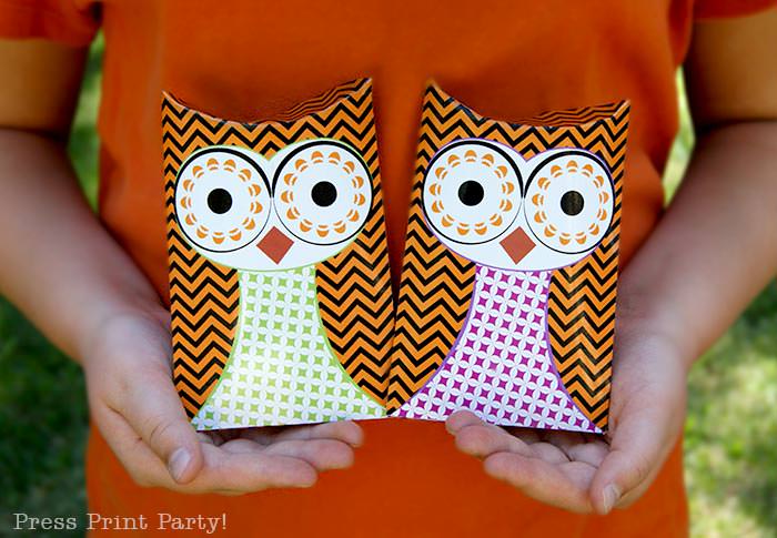 Free printable owl halloween treat boxes, favor bags, Orange, purple and green. Girl with orange shirt holding 2 owl pillow boxes by Press Print Party!