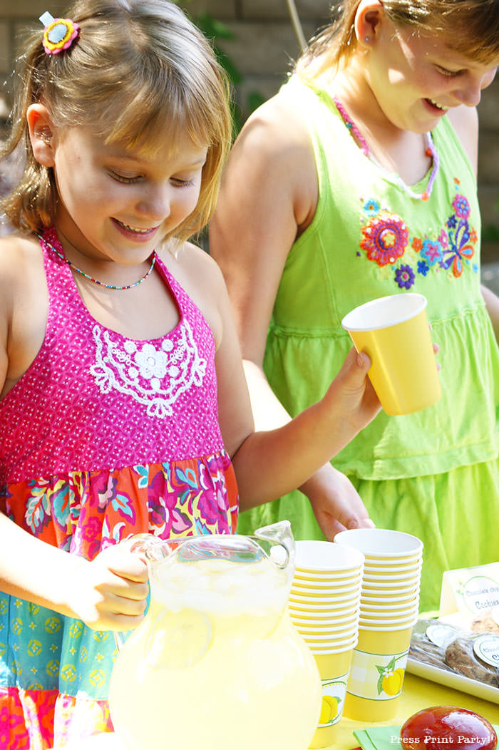 Girls with a lemonade stand. with lemonade banner price list and labels and cupcake wrappers. free printables Press Print Party!