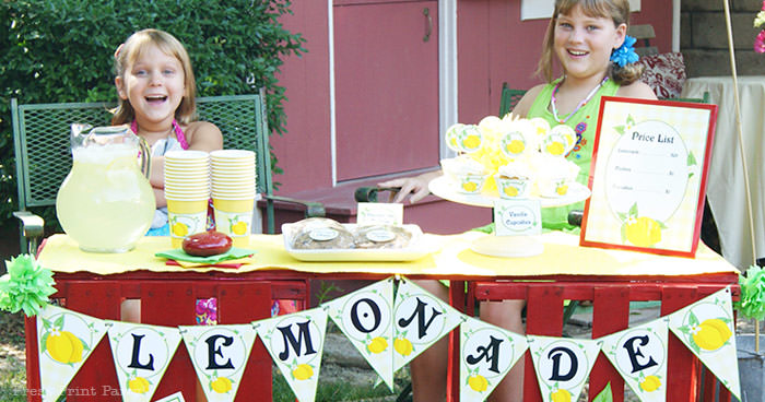 Girls with a lemonade stand. with lemonade banner price list and labels and cupcake wrappers. free printables Press Print Party!