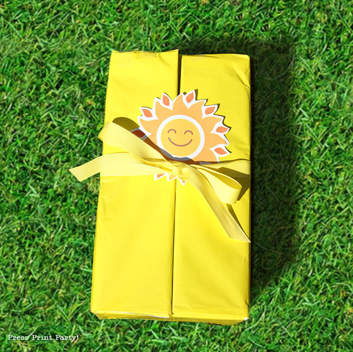 Closed yellow box on grass with happy sun tag