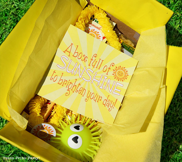 Yellow box with printable happy suns and yellow gifts with text printable sunshine, brighten someone's day.