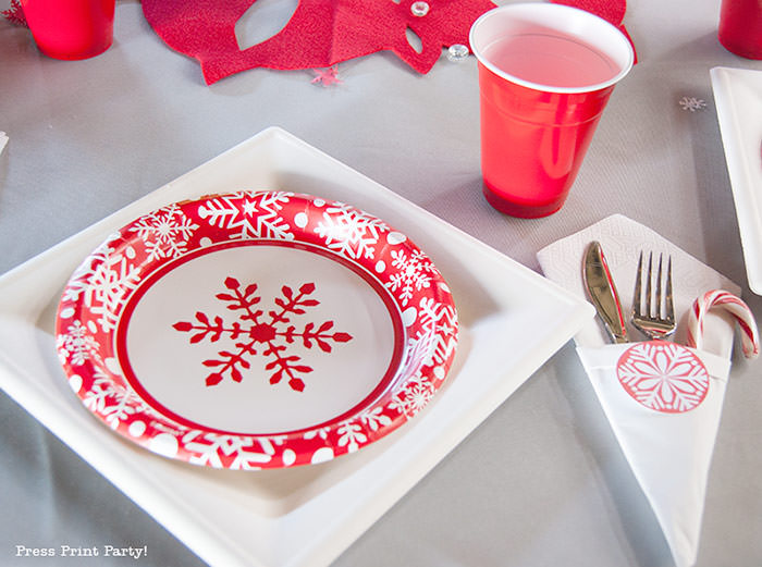 DIY Christmas Centerpiece Ideas red snowflake red and white christmas paper plates with red cup. grey tablecloth.