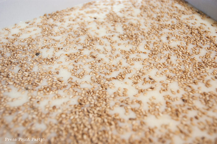 Butter mochi cake with sesame seeds on top before baking