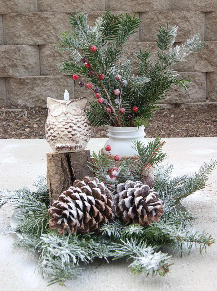 Rustic Christmas table centerpiece with greenery, rustic owl, white mason jar, pinecones, and berries. With a free music sheet table number printable download. With a brown tablecloth and music sheet place mats. Easy and cheap. by Press Print Party!