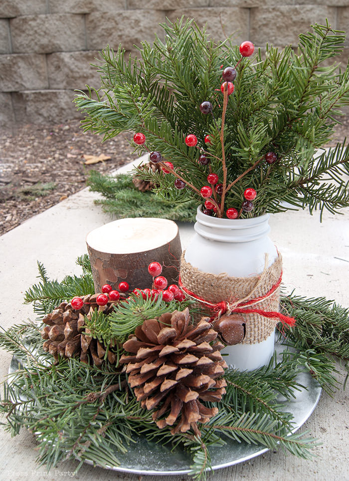 Rustic Christmas table centerpiece with greenery, rustic owl, white mason jar, pinecones, and berries. With a free music sheet table number printable download. With a brown tablecloth and music sheet place mats. Easy and cheap. by Press Print Party!