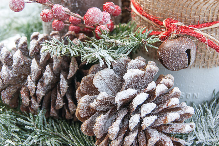 Rustic Christmas table centerpiece with greenery, rustic owl, white mason jar, pinecones, and berries. With a free music sheet table number printable download. With a brown tablecloth and music sheet place mats. Easy and cheap. by Press Print Party!