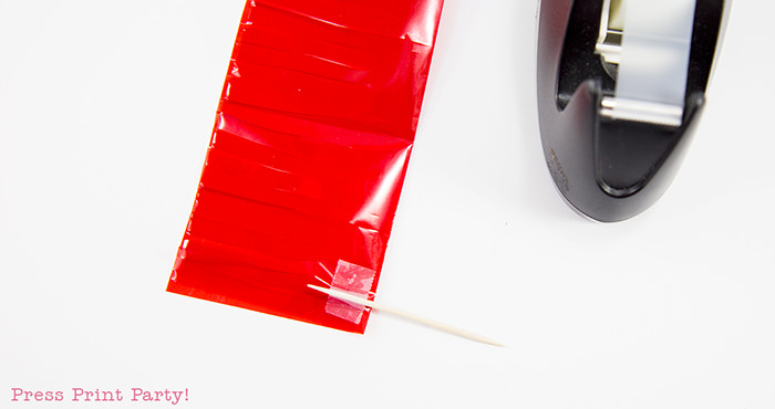 Taping the toothpick for tassel cupcake toppers.