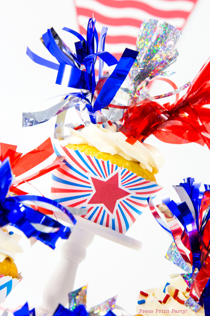 Patriotic cupcake wrapper with red star and 3 tassel toppers in red silver and blue.