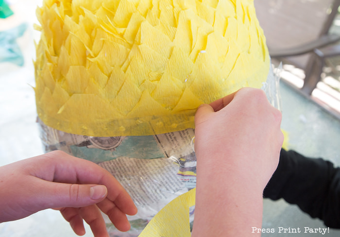 Pineapple Pinata Tutorial, the good, the bad and the funny! How to make a pineapple pinata. By Press Print Party! gluing the streamer on the pinata