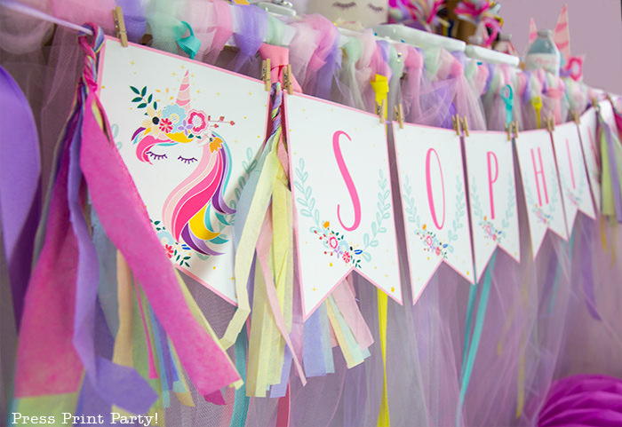 Unicorn banner with rainbow tassels.