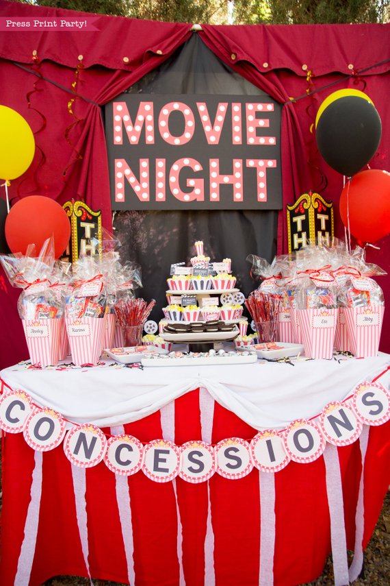Movie NIght party table with marquee letters and popcorn box favors