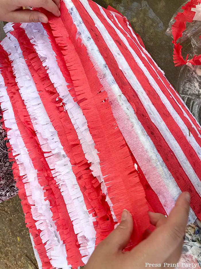 adding fringes to a popcorn box pinata - Press Print Party!