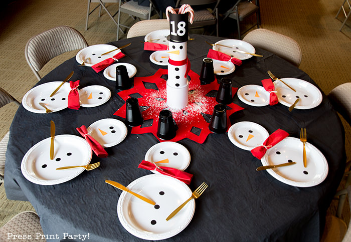 cute Christmas snowman table decor made with cans and felt scarf on a table with snowman made out of white plates - Press Print Party!