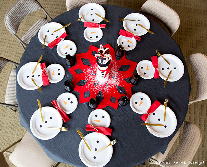 cute Christmas snowman table decor made with cans and felt scarf on a table with snowman made out of white plates - Press Print Party!