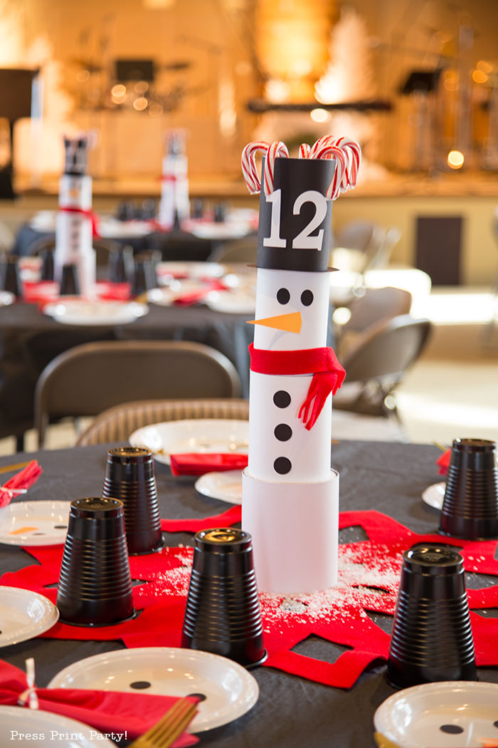 cute Christmas snowman table decor made with cans and felt scarf on a table with snowman made out of white plates - Press Print Party!