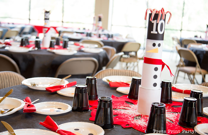 cute Christmas snowman table decor made with cans and felt scarf on a table with snowman made out of white plates church dinner decorations- Press Print Party!