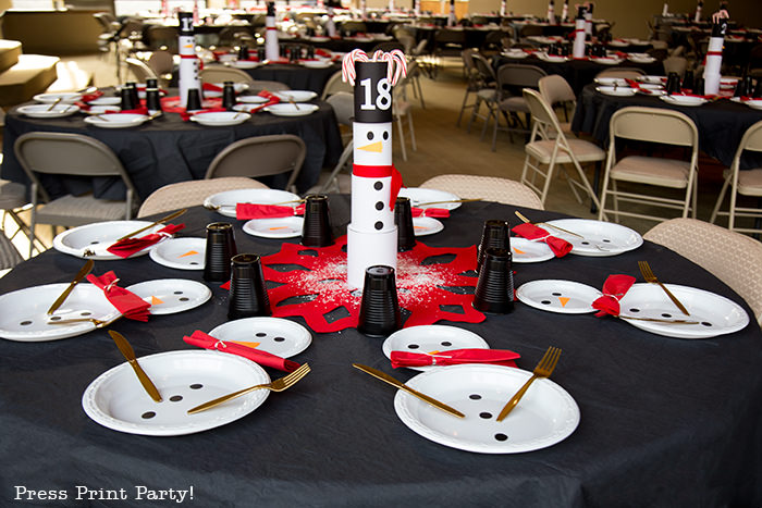 cute Christmas snowman table decor made with cans and felt scarf on a table with snowman made out of white plates church dinner decoration- Press Print Party!