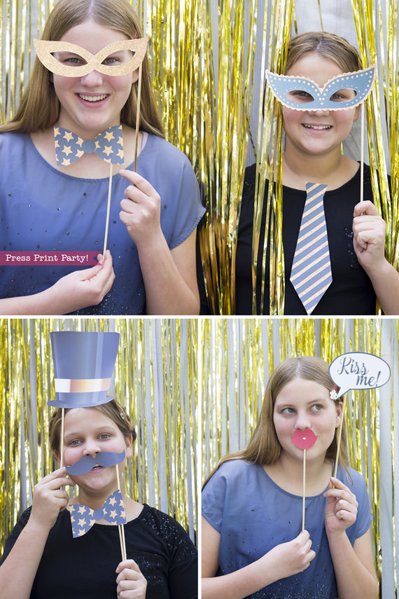 Girls holding New Year's photo booth props with hat, bowtie, mustaches and kiss me sign - Press Print Party!