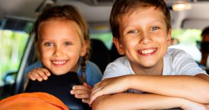 2 kids laughin in car with games to play in the car