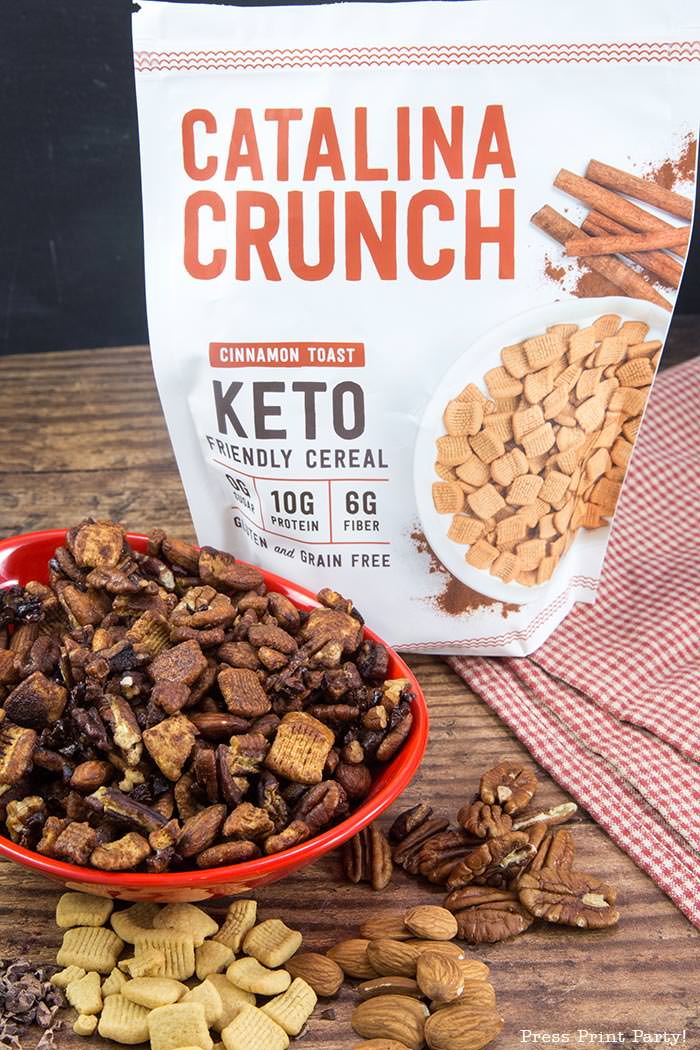 crunchy keto trail mix recipe with catalina crunch cereal, almonds, cocoa nibs, serve, and pecans.