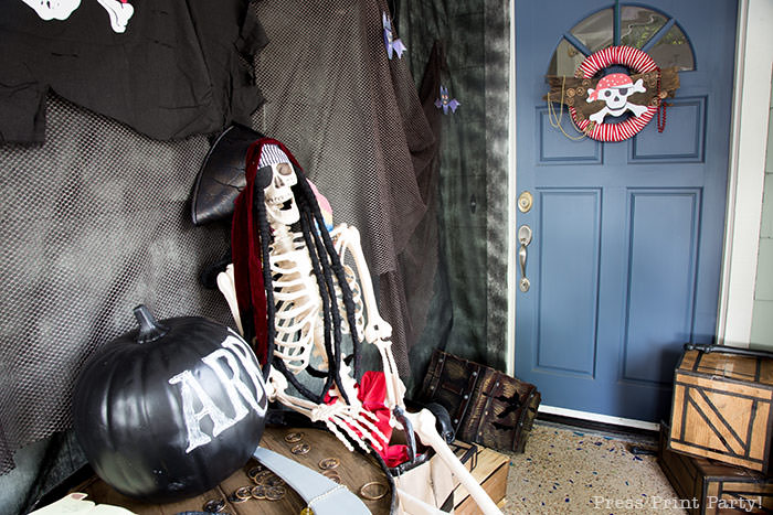 Pirate skeleton with pirate hat and parrot on his shoulder. with a chalkboard pumpkin. Halloween front porch decor ideas - Press Print Party!