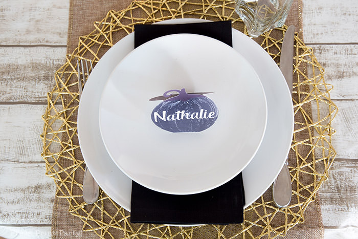 Golden Farmhouse Decorations for Thanksgiving Table. Get inspired with Thanksgiving table decor ideas. White wooden walls with gilded wreath and gold chargers, white plates, black pumpkin place cards, black lantern, golden pumpkins, votives, decorations for thanksgiving table, farmhouse decor ideas, Friendsgiving ideas, thanksgiving table decor, Thanksgiving table setting - tablescape. Press Print Party!