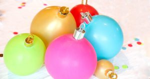 close up of balloon ornament for Christmas table centerpiece. Balloons with ornament toppers in green, gold, blue, red and hot pink. Press Print Party!