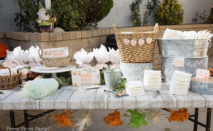 woodland baby shower games table with diapers, how big is mommy's belly, yarn, and thank you notes.Woodland animals Baby Shower Theme with woodland creatures and forest animals party supplies. Woodland decoration girl baby shower ideas. Can be used for woodland birthday party. Rustic forest animals with flowers and antlers. Fox baby shower, Deer baby shower.