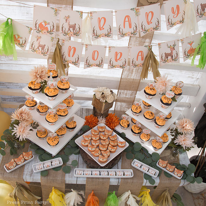 Woodland baby shower dessert table with cupcakes towers and fox macarons. woodland printable banner with cute fox and deer. Woodland animals Baby Shower Theme with woodland creatures and forest animals party supplies. Woodland decoration girl baby shower ideas. Can be used for woodland birthday party. Rustic forest animals with flowers and antlers. Fox baby shower, Deer baby shower.