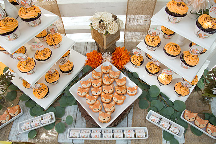 Woodland baby shower dessert table with cupcakes towers and fox macarons. 