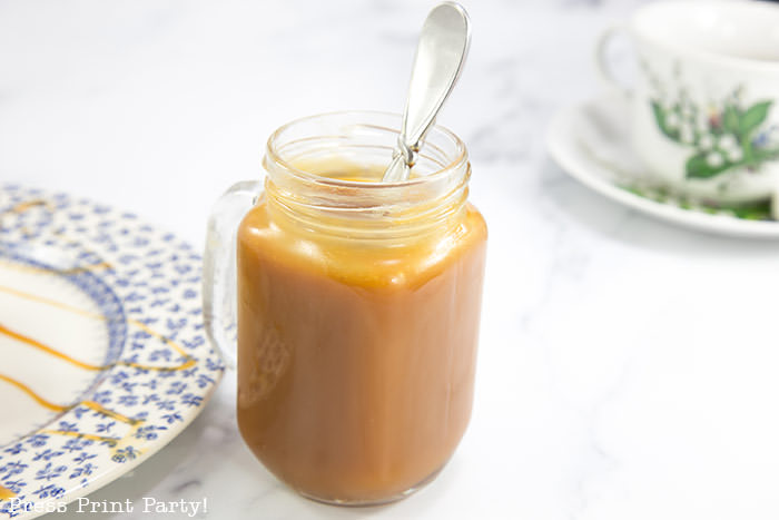 Caramel sauce in mason jar with spoon.How to make a caramel sauce easy recipe for dip or toffee cake or pudding