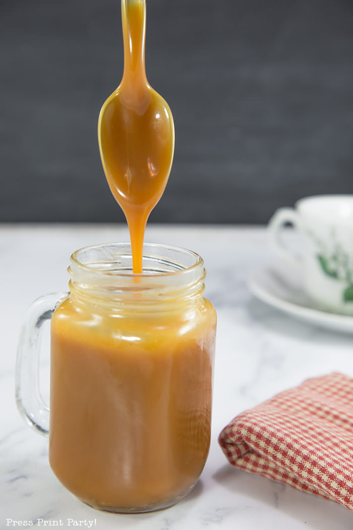 Caramel sauce in mason jar with spoon.How to make a caramel sauce easy recipe for dip or toffee cake or pudding