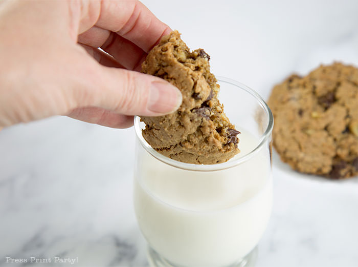 best ranger cookies recipe. chocolate chips and rice krispies cookies being dunked in milk.