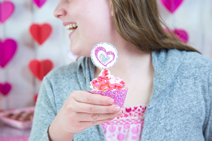 Girl having fun for Galentine's or Valentine's day with glitter heart free cupcake wrappers printables - Press Print Party!