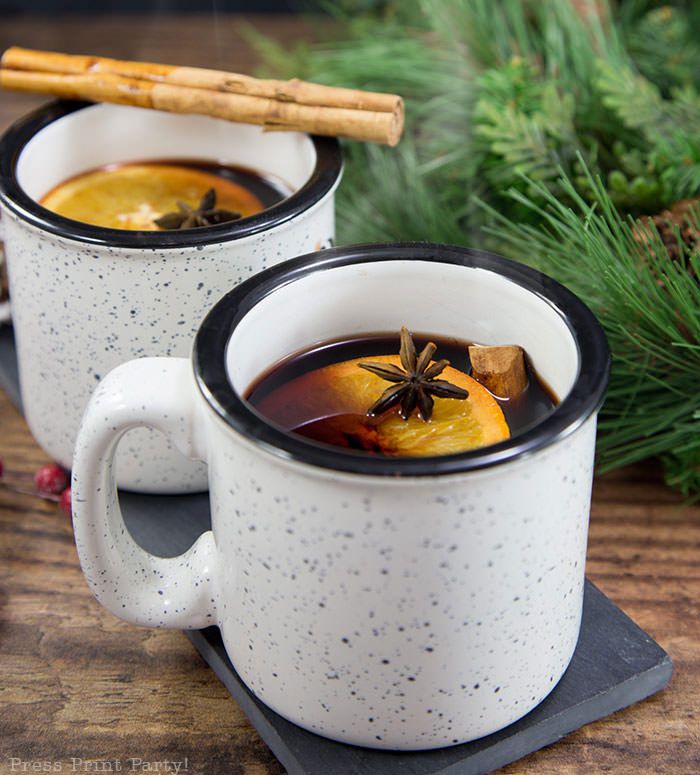 French Vin Chaud, Mulled wine recipe . white cup with hot wine, orange, cinnamon stick, and star anis. Straight from the streets of Paris. Press Print Party!