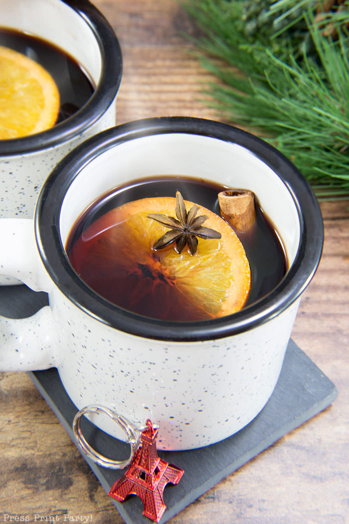 French Vin Chaud, Mulled wine recipe . white cup with hot wine, orange, cinnamon stick, and star anis. Straight from the streets of Paris. Press Print Party!