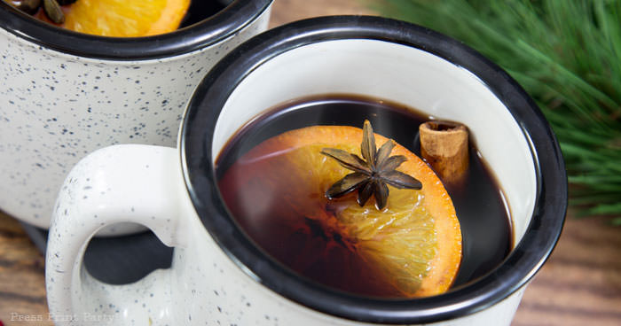French Vin Chaud, Mulled wine recipe . white cup with hot wine, orange, cinnamon stick, and star anis. Straight from the streets of Paris. Press Print Party!