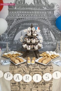 Paris Party Paris Party theme decorations desert table with paris party printables. Eiffel tower backdrop and centerpiece with cupcakes and french flag. Vintage French Party decorations and treats. With Paris banner and red whit and blue balloons. Press Print Party!