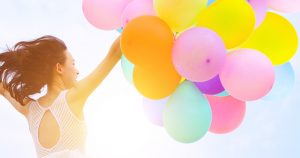 girl jumping with balloons