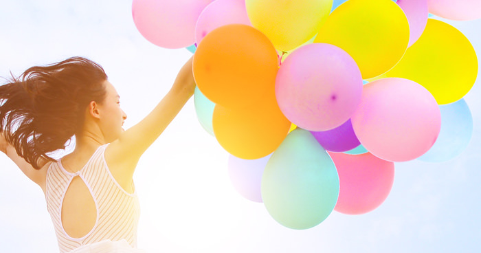 girl jumping with balloons