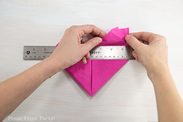 Heart Fold Napkin instructions- How to fold a napkin like a heart - paper napkin or cloth napkins - By Press print Party. Pink paper napkin folded like a heart DIY tutorial