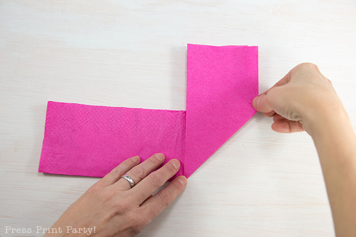 Heart Fold Napkin instructions- How to fold a napkin like a heart - paper napkin or cloth napkins - By Press print Party. Pink paper napkin folded like a heart DIY tutorial