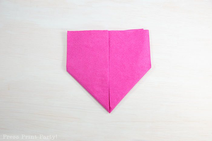 Heart Fold Napkin instructions- How to fold a napkin like a heart - paper napkin or cloth napkins - By Press print Party. Pink paper napkin folded like a heart DIY tutorial