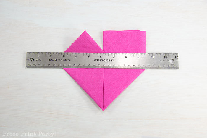 Heart Fold Napkin instructions- How to fold a napkin like a heart - paper napkin or cloth napkins - By Press print Party. Pink paper napkin folded like a heart DIY tutorial