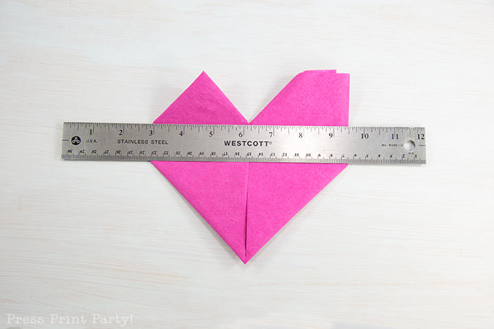 Heart Fold Napkin instructions- How to fold a napkin like a heart - paper napkin or cloth napkins - By Press print Party. Pink paper napkin folded like a heart DIY tutorial