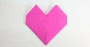 Heart Fold Napkin instructions- How to fold a napkin like a heart - paper napkin or cloth napkins - By Press print Party. Pink paper napkin folded like a heart DIY tutorial