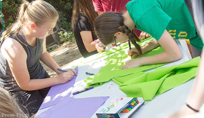 Girls making team bandannas for the amazing race party - Press Print Party