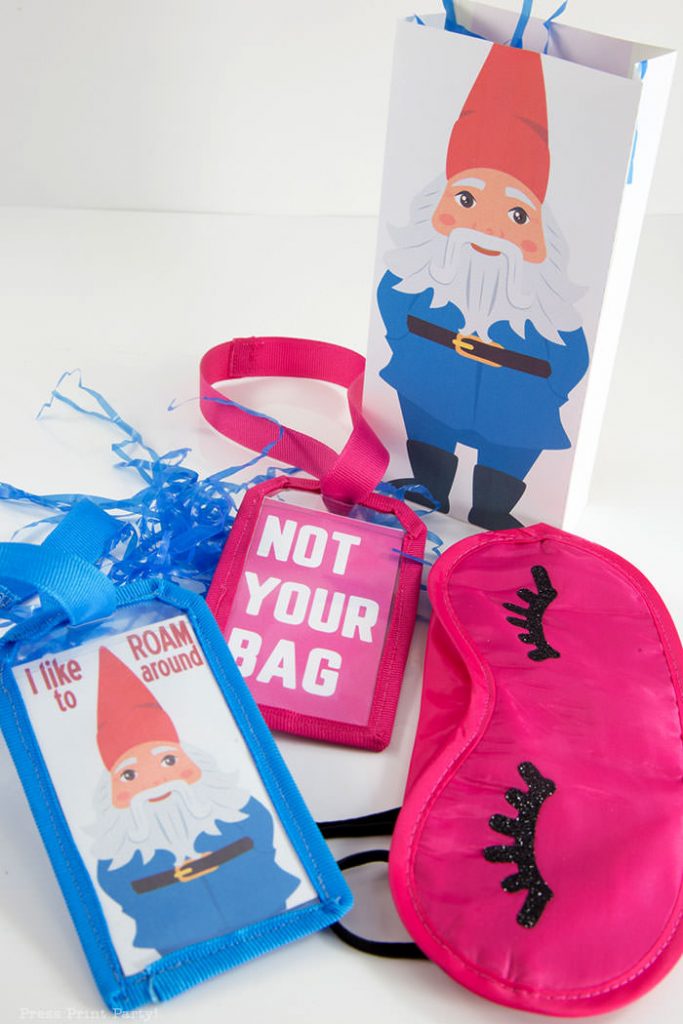 Amazing Race Party Favor Bags with sleep mask with eyelashes and 2 luggage tags, one with a roaming gnome that says I like to roam around and one with Not Your Bag in pink. Press Print Party!